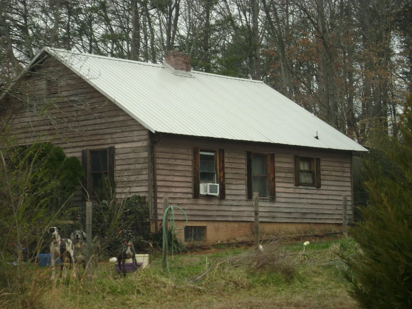White metal roof on an old wood sided farmhouse, from a Metal Roof Installation job in Duncanville